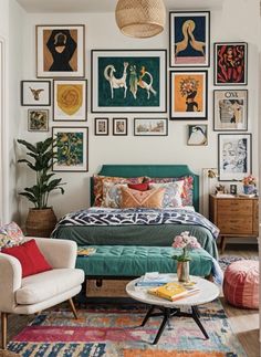 a bedroom with pictures on the wall and a bed in the middle, surrounded by colorful rugs