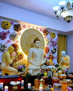 the buddha statue is surrounded by flowers and candles