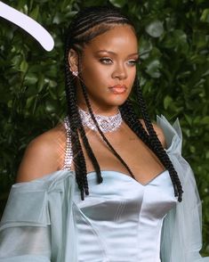 a woman with long braids wearing a blue dress