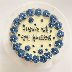 a cake decorated with blue flowers and writing in korean