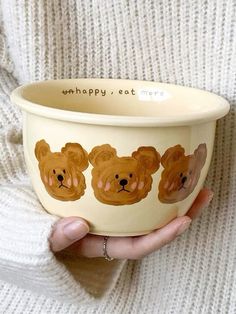 a woman holding a bowl with bears painted on it