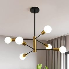 a chandelier hanging from the ceiling in a living room with potted plant