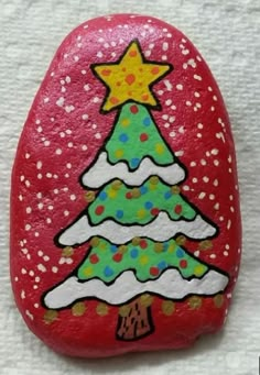 a painted rock with a christmas tree on it