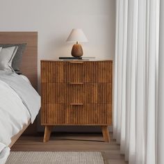 a bedroom with a bed, nightstand and white curtains