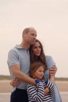 a man and woman hugging each other on the beach