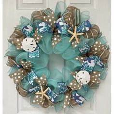 a wreath that is on the front door with starfishs and seashells