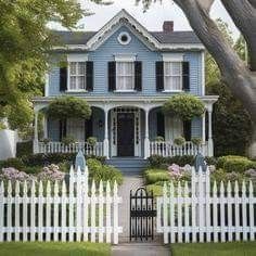 a white picket fence in front of a blue house