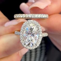 a close up of a person holding an engagement ring