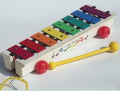 an xylons toy sitting on top of a white table next to a pair of yellow mallets