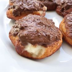 chocolate covered doughnuts on a white plate with melted cheese in the middle,