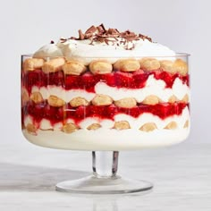 a cake with white frosting and cookies on top is sitting on a glass pedestal