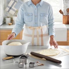 a woman in an apron is making bread