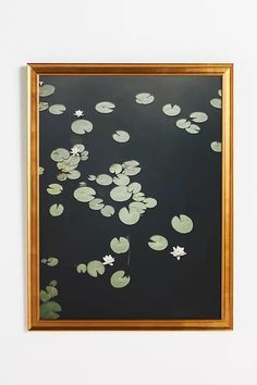 a painting hanging on the wall with water lilies