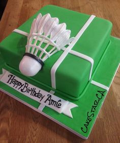 a green birthday cake with white lacrosse sticks and net on it's side that says happy birthday amiie