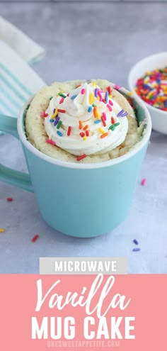 microwave vanilla mug cake with whipped cream and sprinkles in a blue cup