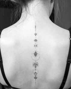 the back of a woman's neck with an intricate design on her lower back