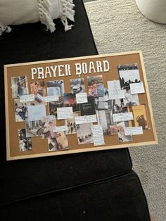 a bulletin board with pictures on it sitting on the floor in front of a couch