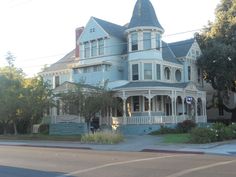 an old victorian style house on the corner of a street