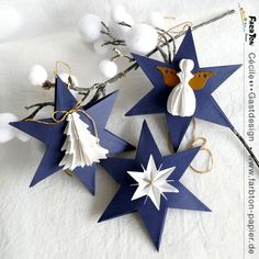 two blue and white paper stars with angels on them