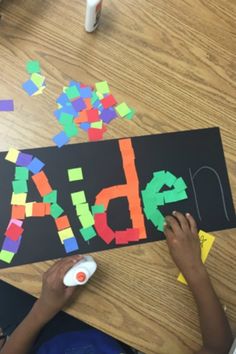 a child is making a name made out of construction paper