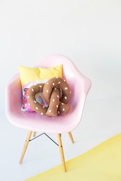 a pink chair with a pillow on it and a donut shaped pillow in the middle