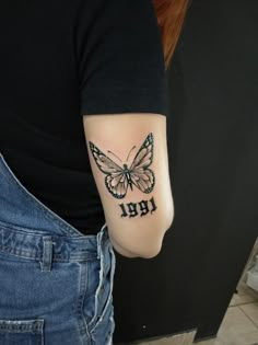 a woman with a butterfly tattoo on her arm