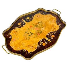 an ornately decorated wooden tray with gold trimmings and floral designs on it