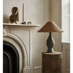 a lamp sitting on top of a table next to a fireplace