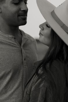 a man standing next to a woman wearing a cowboy hat