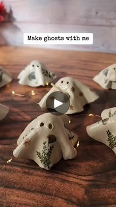 some white ghost figurines on a wooden table with lights coming from them and the words make ghosts with me