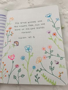 an open notebook with colorful flowers and the words, the grace whispers and the provers fade but the waters never find ends forever