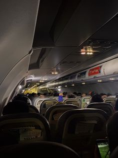 the inside of an airplane with people sitting on seats