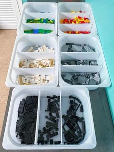 legos are arranged in trays on the floor