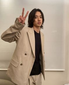 a man standing in front of a whiteboard making the peace sign with his hand