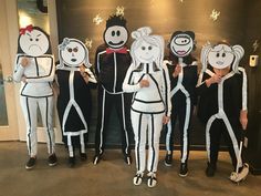 several people in costumes standing next to each other with paper cutouts on their faces