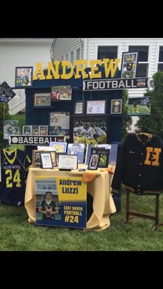 a table with pictures and memorabilia on it in front of a football team's jersey display