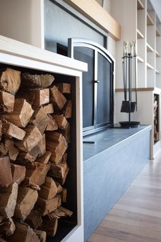 a stack of logs sitting in front of a fireplace