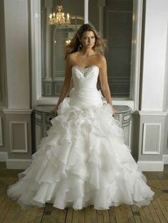 a woman in a white wedding dress is standing