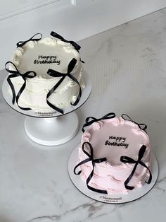 two birthday cakes sitting on top of each other in front of a white marble counter