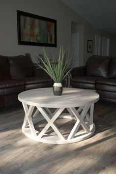 a white coffee table with a potted plant on it in the middle of a living room