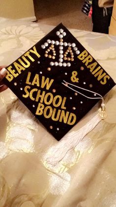 a black and gold graduation cap with the words beauty, brain & law school bound on it