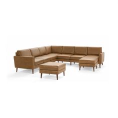 a sectional couch with ottoman and footstool in tan leather, viewed from the front