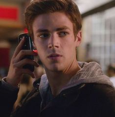 a young man is talking on his cell phone