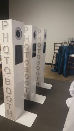 three tall white speakers sitting on top of each other in front of a blue table cloth