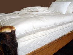 a bed with white sheets and pillows in a room