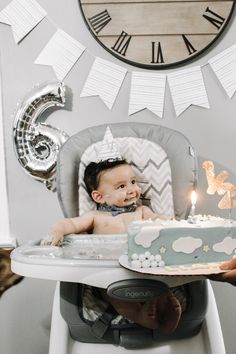 a baby in a high chair with a cake