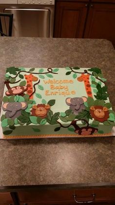 a baby shower cake decorated with monkeys and giraffes