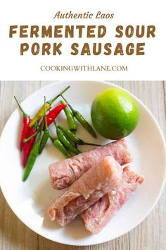 the ingredients for fermented sour pork sausage on a white plate with limes and peppers