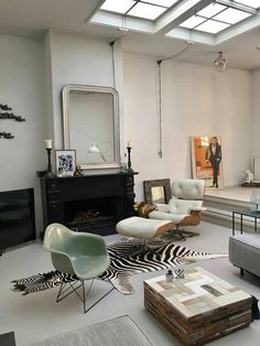 a living room filled with furniture and a fire place in the middle of the room