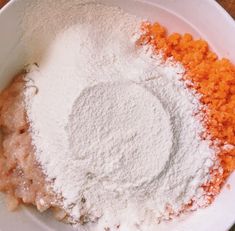 a white bowl filled with dry ingredients on top of a wooden table